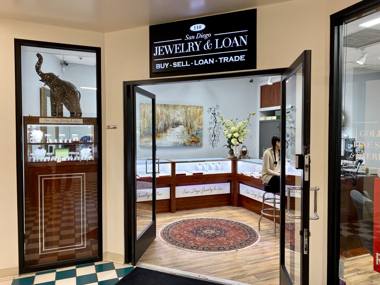 San Diego Jewelry & Loan storefront — Suite 110 inside the Jewelers Exchange, with display cases and the BUY · SELL · LOAN · TRADE sign